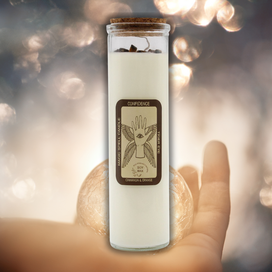 Glass jar with a candle inside, held by a hand against a blurred light background