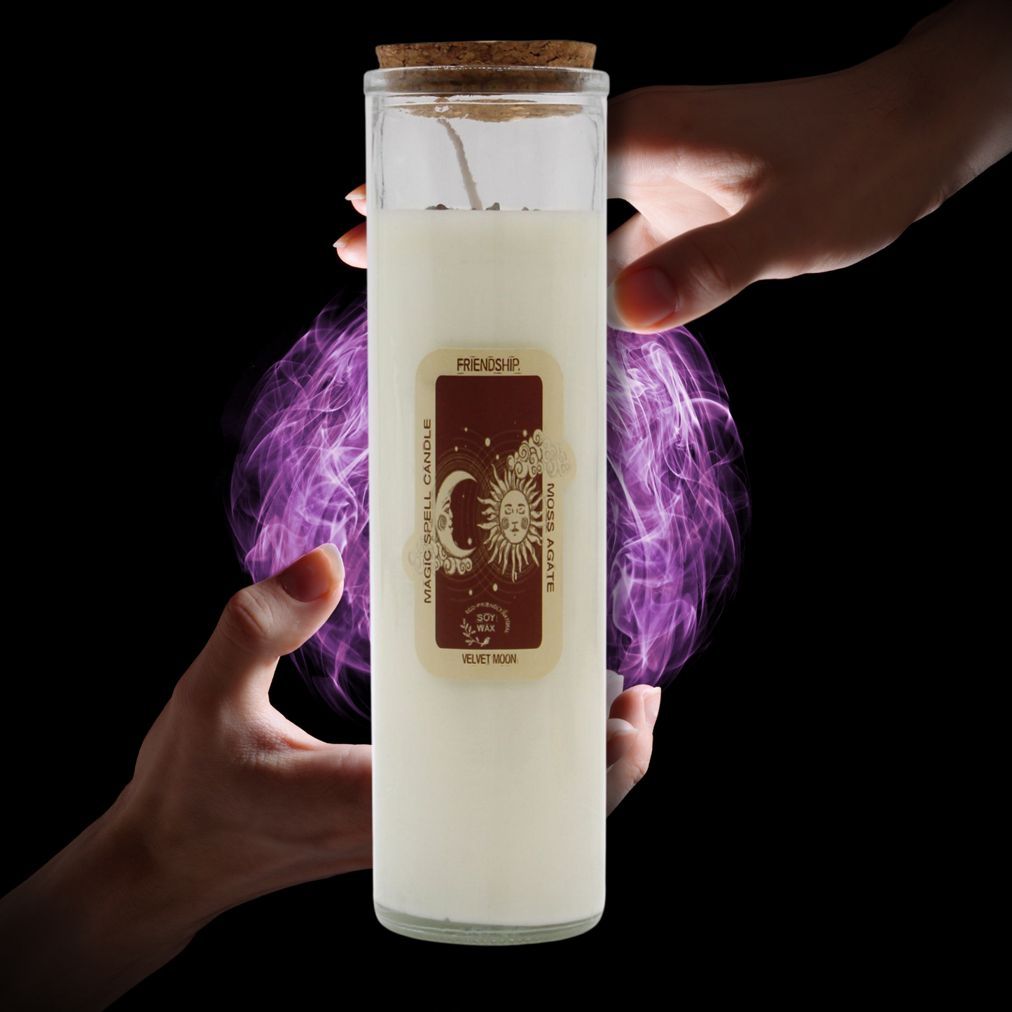 Candle in a glass jar labeled 'Friendship' held by hands with purple smoke effect on a black background